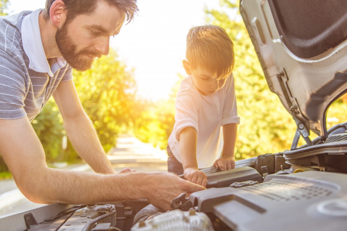 man and his kid working on their car