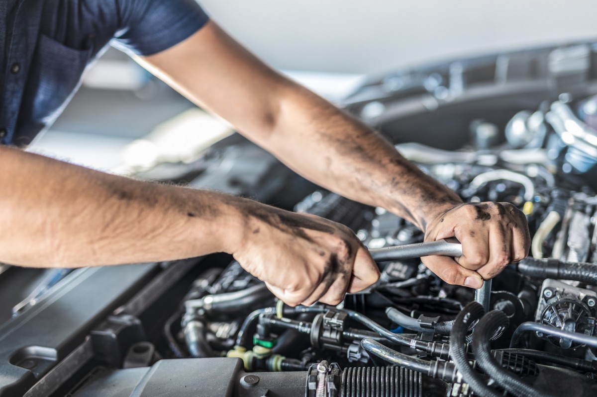 mechanic turning a wrench on a car